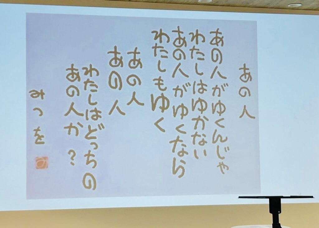 みつをの詩「あの人がゆくんじゃわたしはゆかない」を映したスライド。